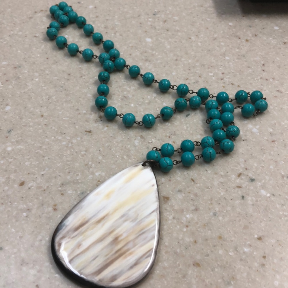 Turquoise bead and beige pendant necklace.